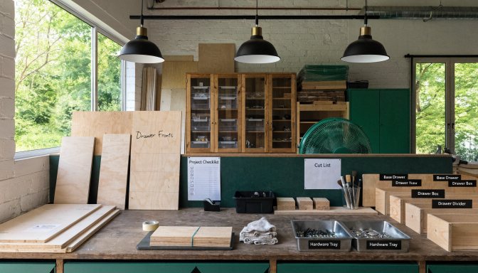 Organized woodworking project workspace with labeled parts and staged materials